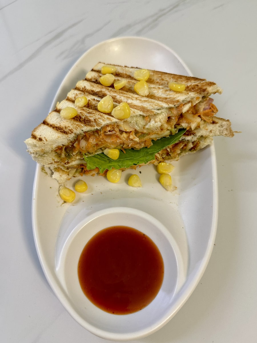 Corn and Spinach Sandwich - A wholesome sandwich filled with creamy corn and spinach, served in toasted bread.