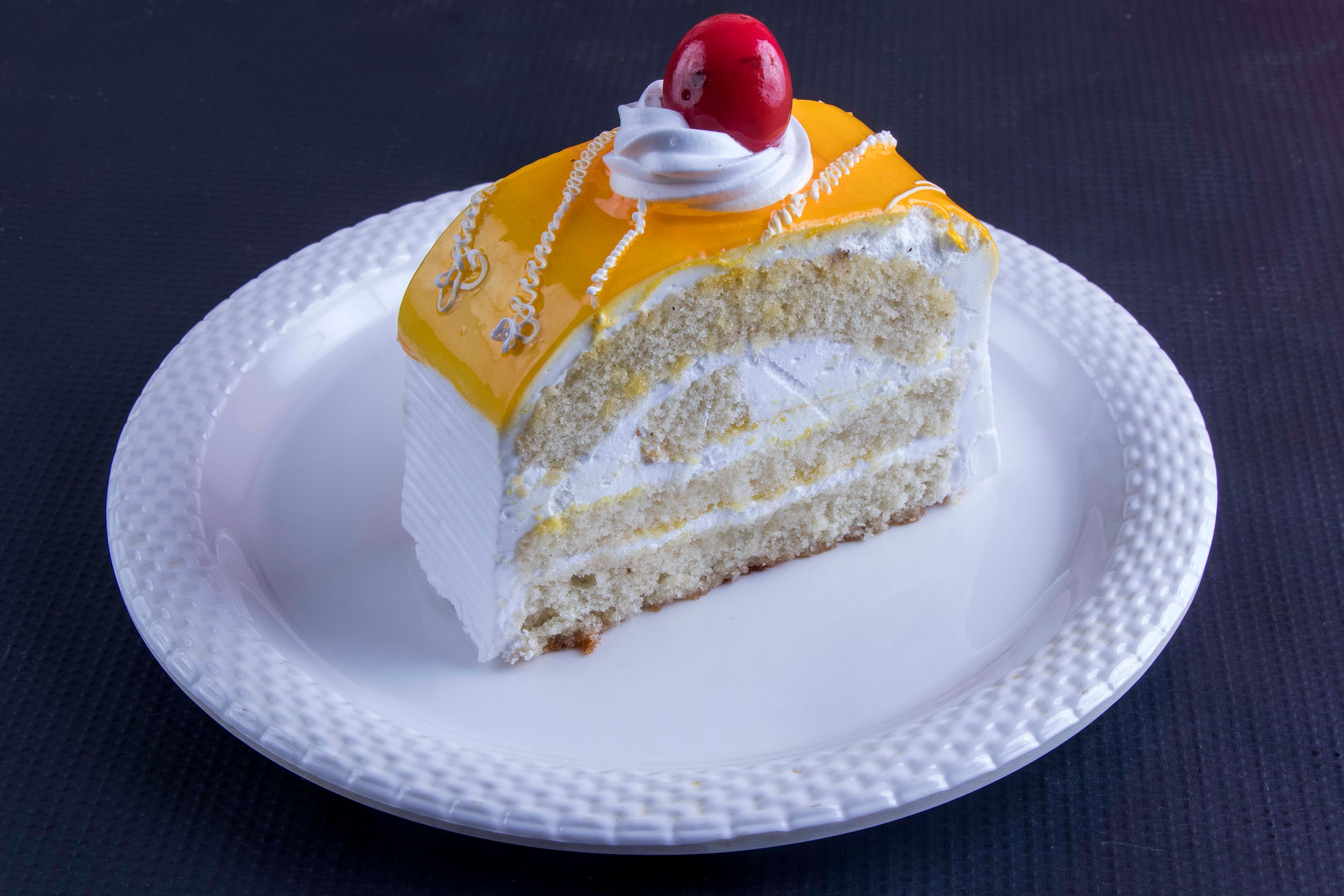 Asian style fluffy layers mango cake pastry with cream, fresh mango on  white plate Stock Photo - Alamy