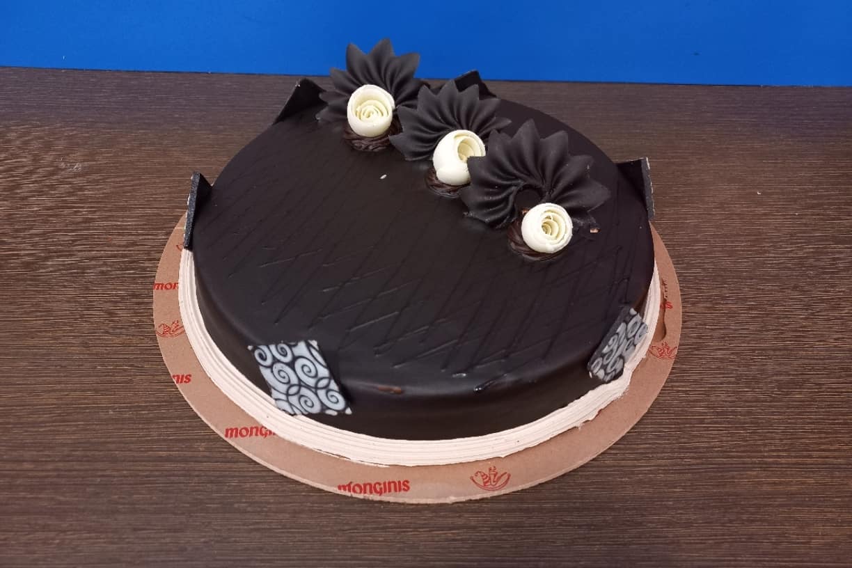 Monginis Cake Shop - Manmad - A beautiful Dark Sponge Layered Chocolate Cake  embellished with chocolate balls, twisters, chocolate bars, and even a mini  pinata cake! This eggless cake is your dream