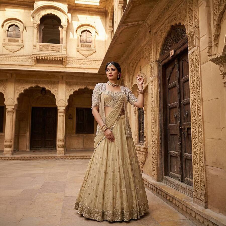 A luxurious golden bridal lehenga set featuring intricate embroidery, a designer blouse, and an elegant dupatta