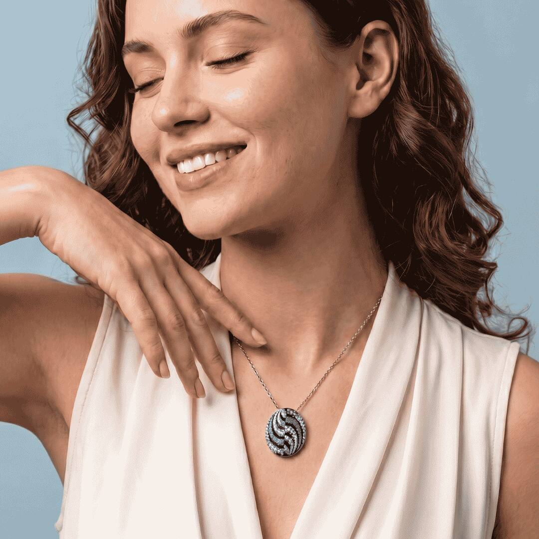 Titanium pendant featuring oval shaped enamel artistry with diamonds