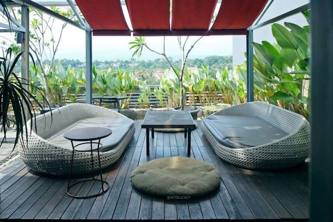 Tier Siera dengan dua kursi sofa memanjang, di bawah kanopi dengan suasana dedaunan sejuk